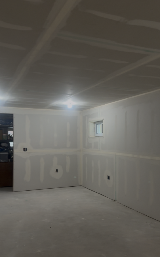Basement finishing project with fresh drywall and taped seams