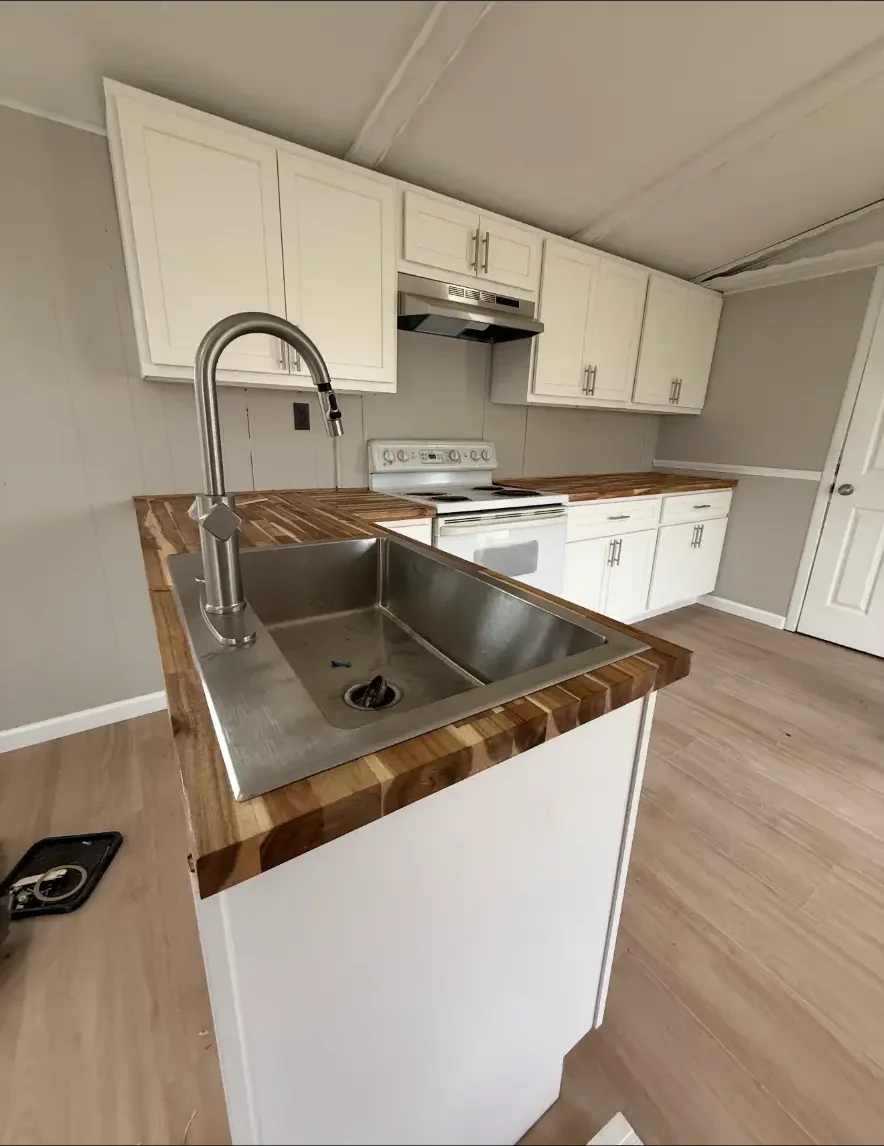 Custom kitchen island with butcher block countertop and stainless sink